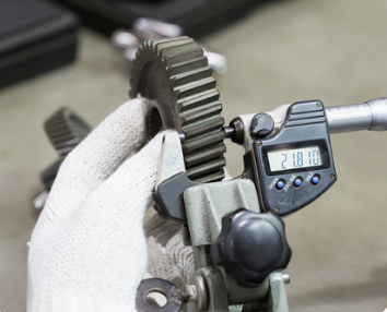 Image of gloved hand holding cog with measurement too read to 21.810 - Winchester Interconnect providing increase in flex cycles
